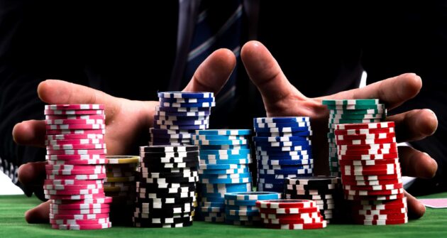 une paire de mains tenant une grosse pile de jetons de poker