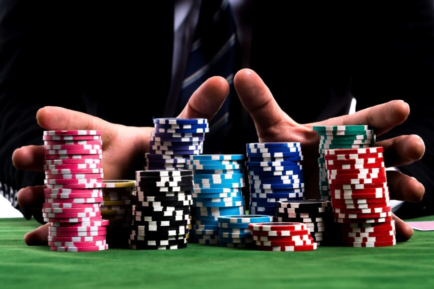 une paire de mains tenant une grosse pile de jetons de poker