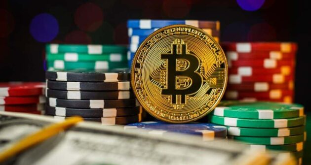 bitcoin couché à côté de jetons de poker sur une table
