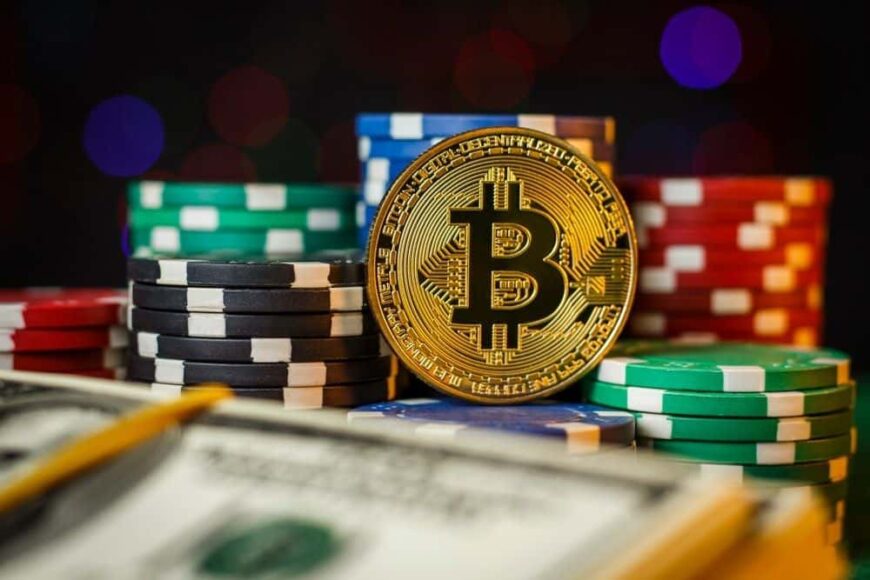 bitcoin couché à côté de jetons de poker sur une table