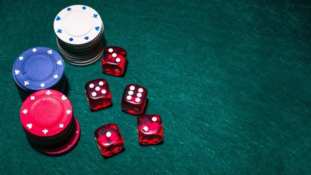 dés rouges et jetons de poker sur une table verte